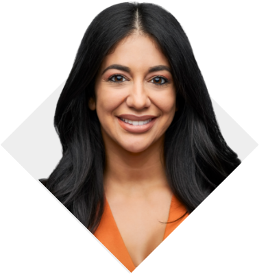 A woman with dark brown straight hair smiling and wearing an orange shirt